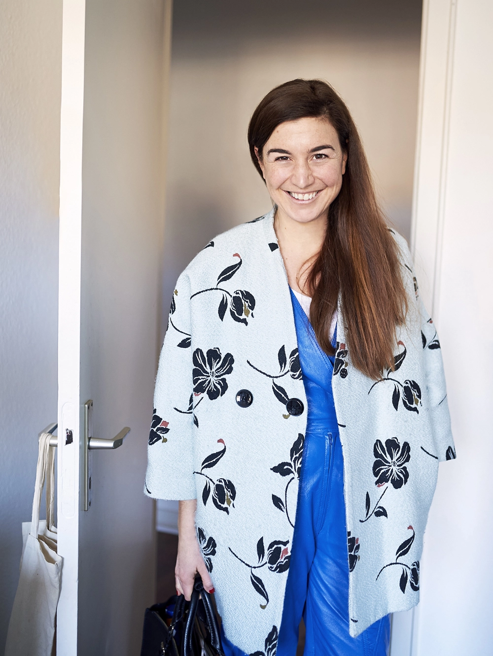 Janine Dudenhöffer, Sustainable Stylist, trägt einen blauen Anzug und eine und weißen Mantel mit Blumen